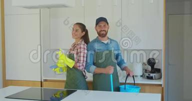 一对夫妇的肖像，<strong>作为</strong>一名职业清洁工，穿着制服，站在一起，在室内使用清洁工具。